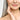 Sunlighten Model with gray hair is touching her youthful skin