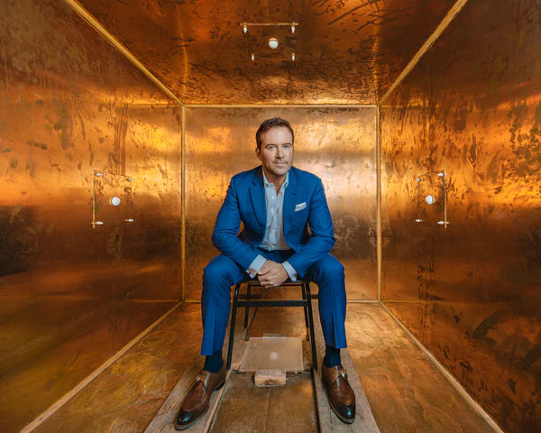 Founder of Osmosis Dr Ben Johnson in a blue suit sitting in a copper room