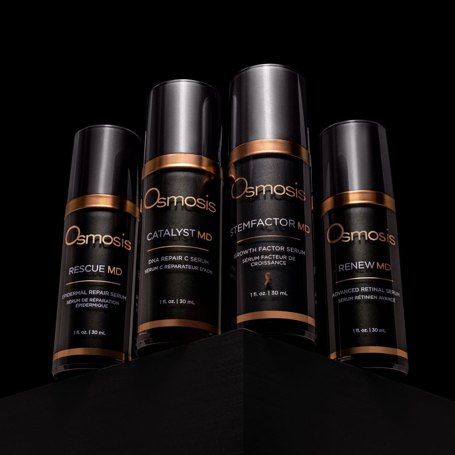 four black and gold bottles of md advanced skincare collection on black background
