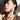 Close up of a model with healthy skin holding a bottle of osmosis perfection pigment corrector near her face