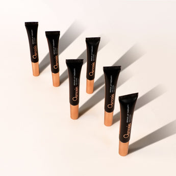 Six black and metallic tubes of osmosis repair lip therapy are displayed upright on white counter