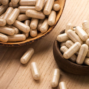 two brown bowls full of supplement capsules on countertop