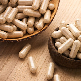 two brown bowls full of supplement capsules on countertop