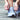close up of a female tying her blue tennis shoes outside