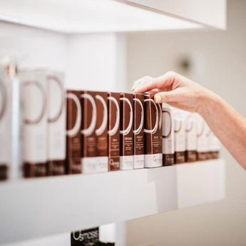 white salon shelving holding multiple tubes of osmosis skincare beauty products displayed in a row