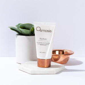 hydrate beauty products displayed with a plant and bowl on white countertop