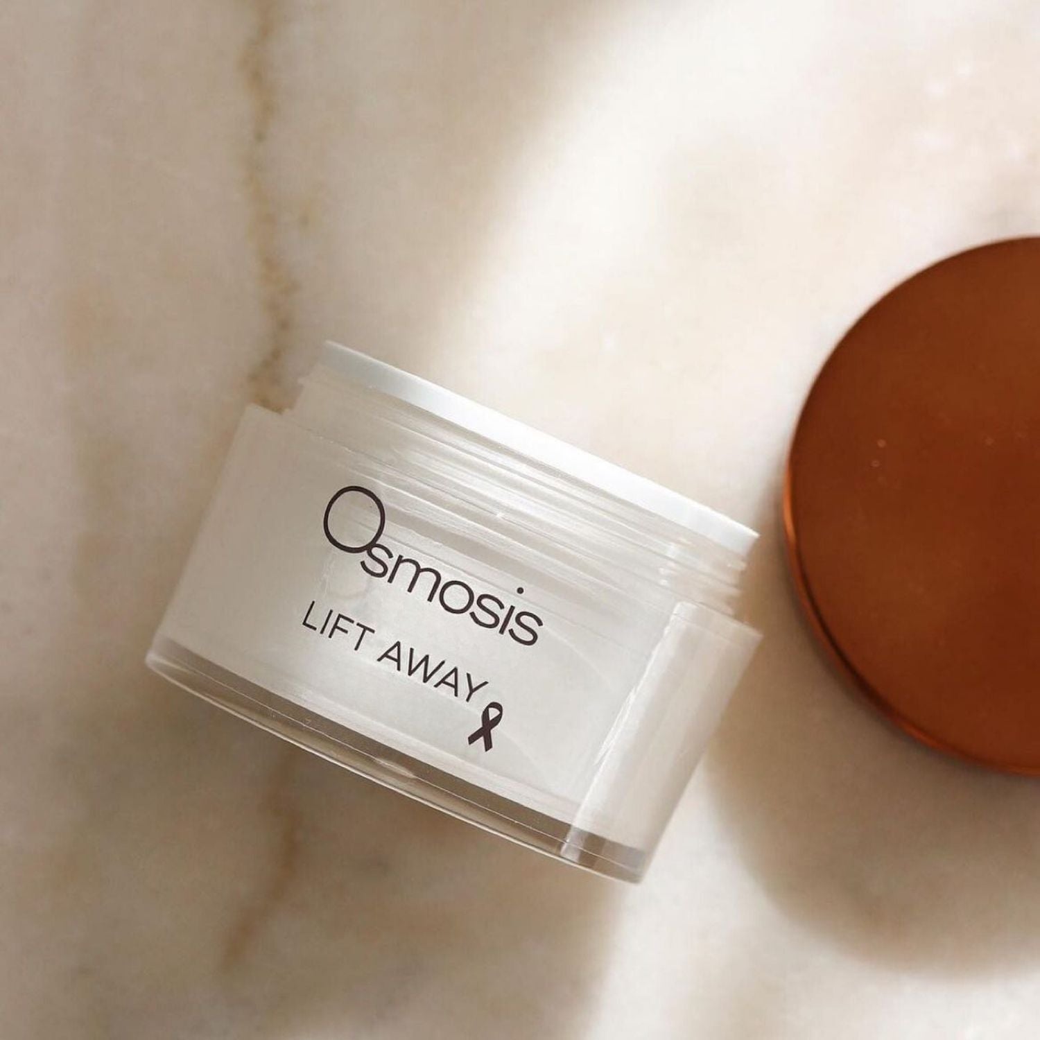 opened jar of osmosis lift away beauty skincare displayed on countertop 