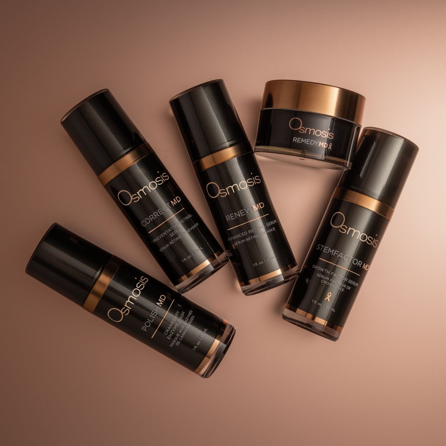 five bottles of black and gold md advanced skincare collection on rose gold background