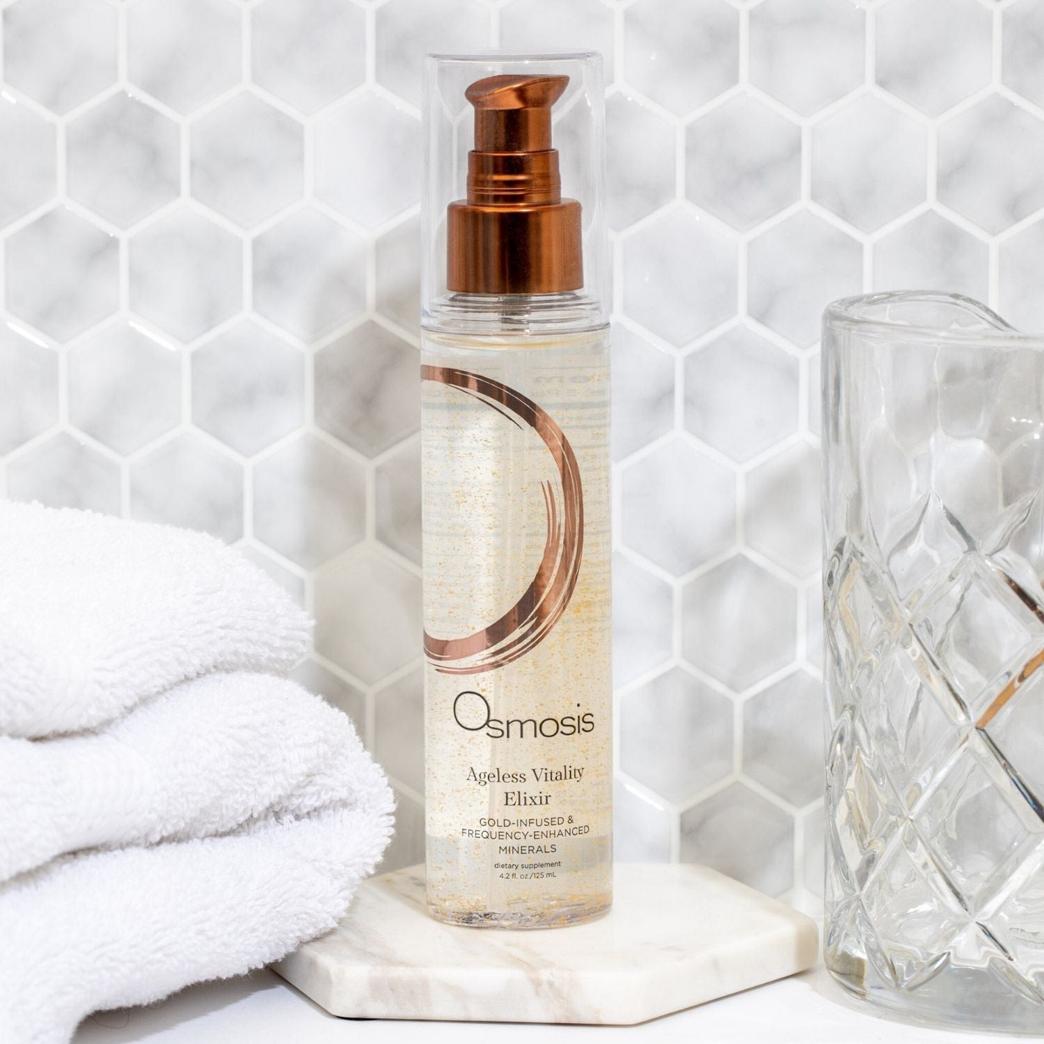 Bottle of Osmosis skincare displayed on counter in a modern white bathroom