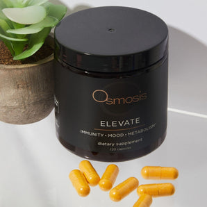 jar of elevate with supplement capsules displayed on white counter with plant