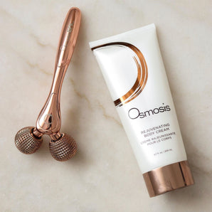 tube of rejuvenating body cream and roller tool displayed on marble countertop