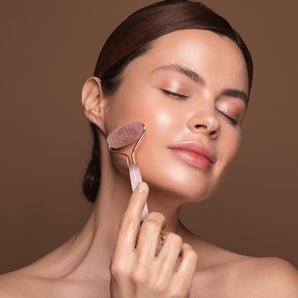 Close up of model using rose quartz skin roller on her face