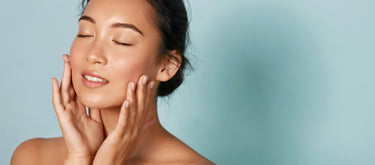 fountain of uth female model is holding her hands up to her healthy glowing skin with a light blue background