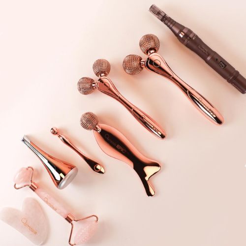 eight various rose colored body tools by osmosis are lined up on a countertop